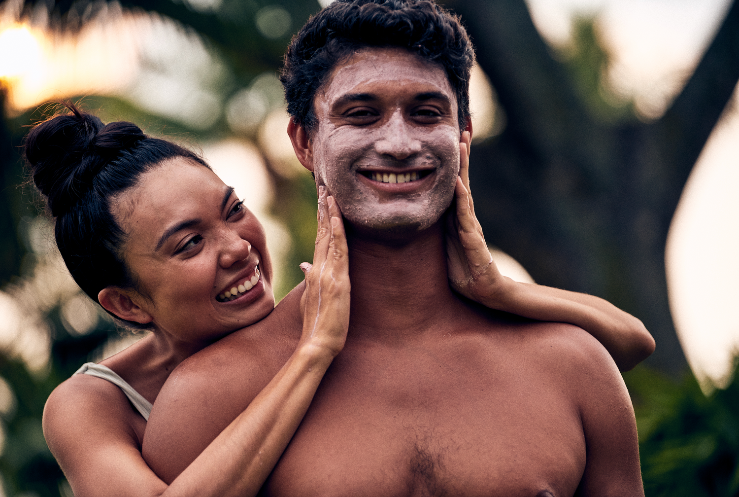 This image shows a man and a woman outside smiling while applying a mineral powdered face mask as a more sustainable plastic free alternative to single use sheet face masks. These are a part of Desesh's range of zero waste, plastic free, eco friendly, more sustainable personal care and everyday essential products.