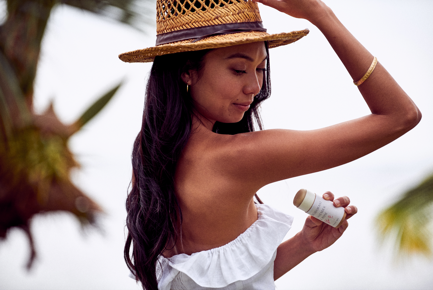 This image shows the Desesh plastic free aluminum free natural deodorant. In this image is the lavender and rose scent which uses essential oils. In the photo a women is applying the deodorant to her underarm and it is in a biodegradable push up cardboard tube