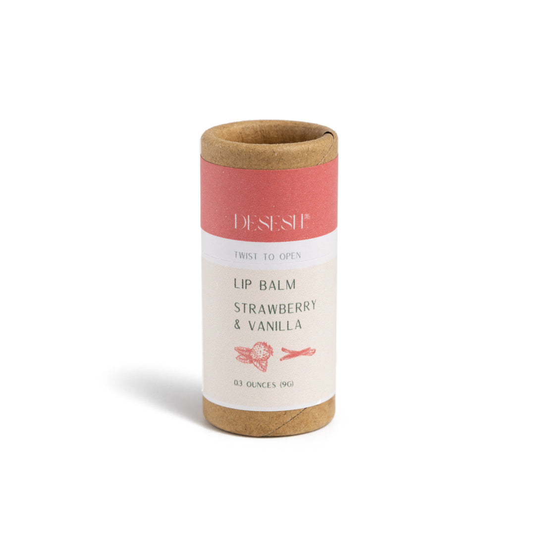 This image shows the Desesh natural plastic free lip balm in a paper based cardboard push up tube for a more eco friendly sustainable zero waste lip balm. Shown here is the strawberry and vanilla flavor which uses essential oils and extract oils as a natural fragrance