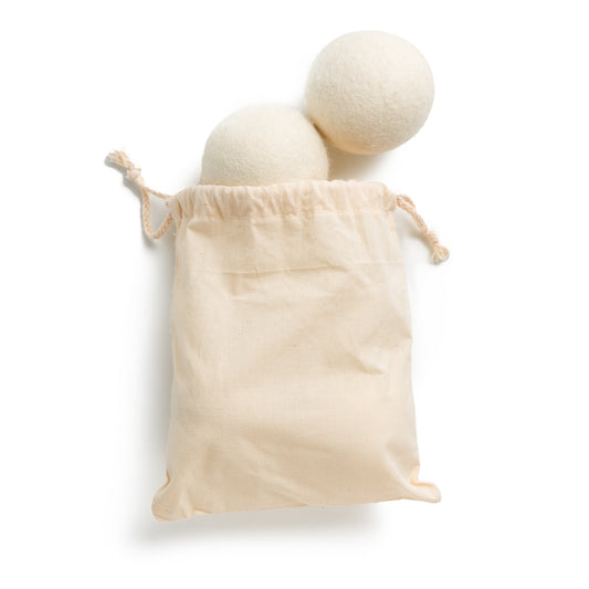 This image shows a pack of four wool dryer balls to reduce static and increase drying time of clothes in an automatic clothes dryer. The wool dryer balls come in a reusable plastic free cotton bag. These wool dryer balls are designed for a plastic free zero waste more sustainable eco friendly routine and are an alternative to single use disposable dryer sheets