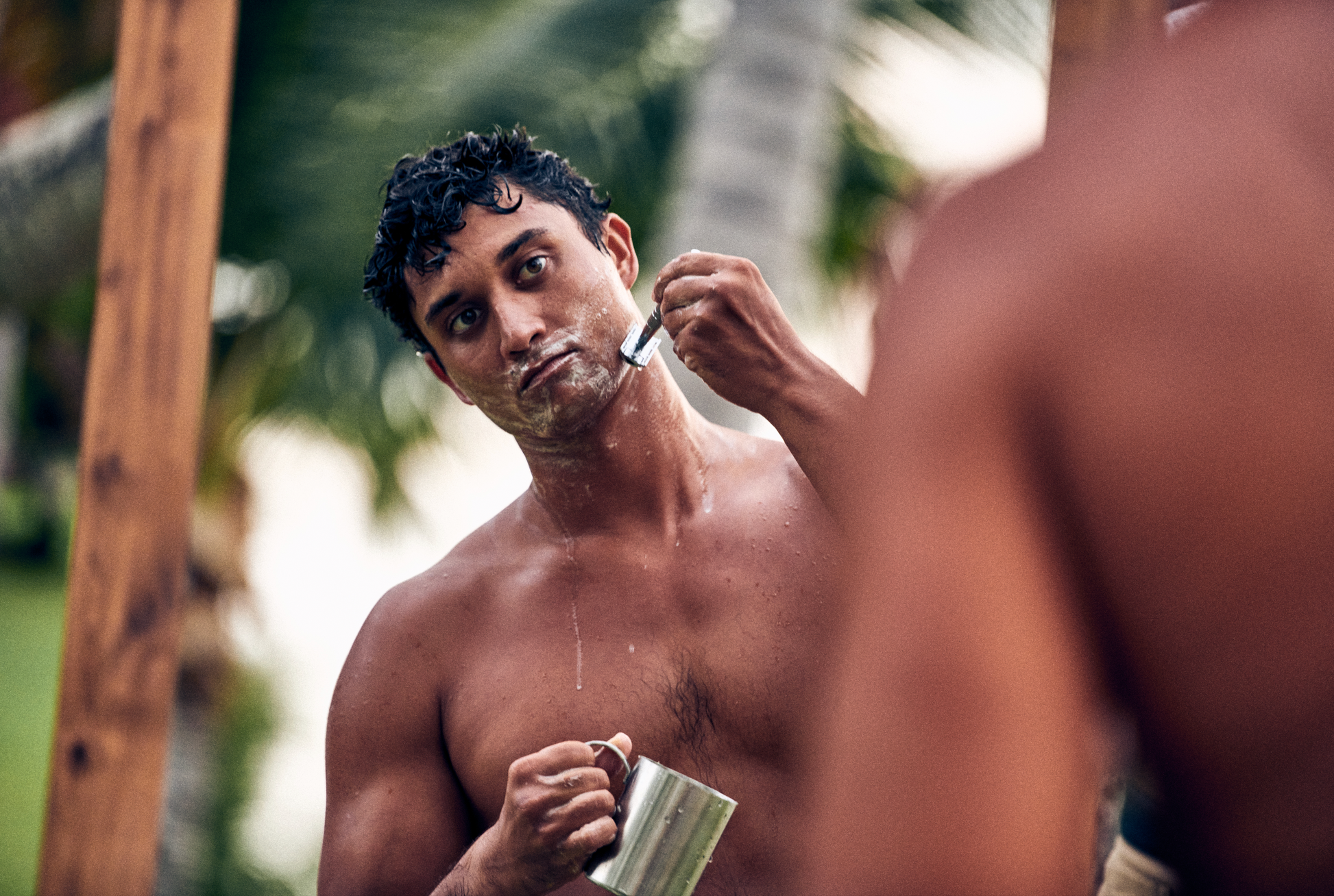 This image shows the Desesh premium quality solid body and face shave soap bar as an alternative to cans of shave foam or cream. This is a more eco friendly sustainable zero waste option and the shave bars come in biodegradable packaging. Shown here is a man shaving his face using a metal reusable safety razor and a solid shave soap bar for a plastic free sustainable shave routine