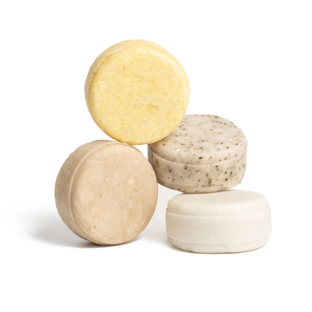 This image shows salon quality Shea Butter solid shampoo bars with plastic free biodegradable packaging for a more sustainable eco friendly zero waste hair care routine. Shown here are the four shea butter solid shampoo bars without their biodegradable packaging boxes